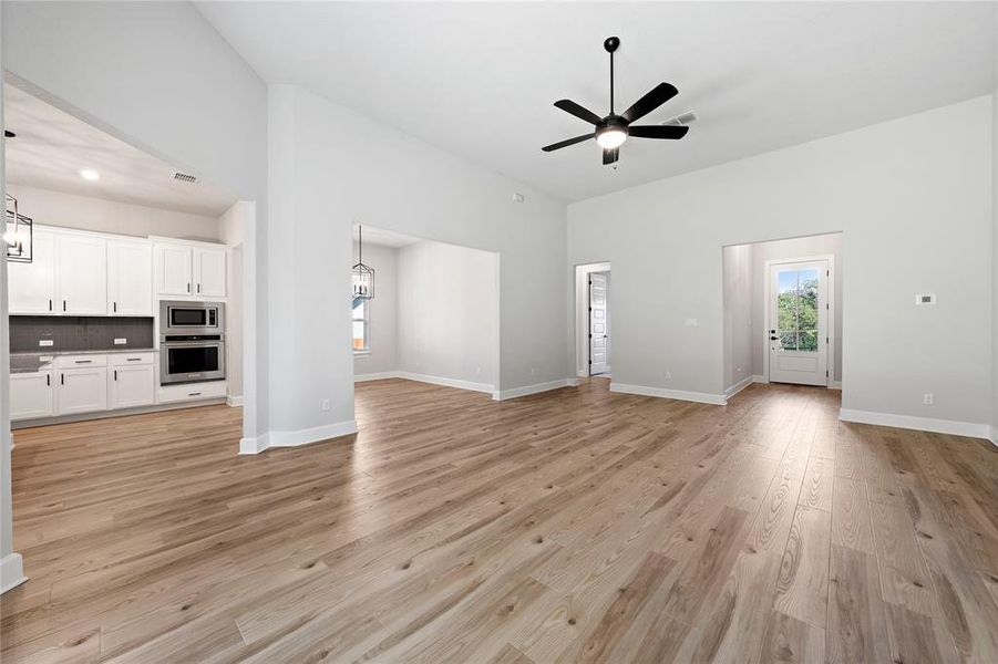 Living room/Entertainment room includes ceiling fan, beautiful vinyl floors, and sliding glass doors.