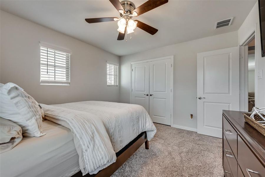 Carpeted bedroom featuring a closet and ceiling fan