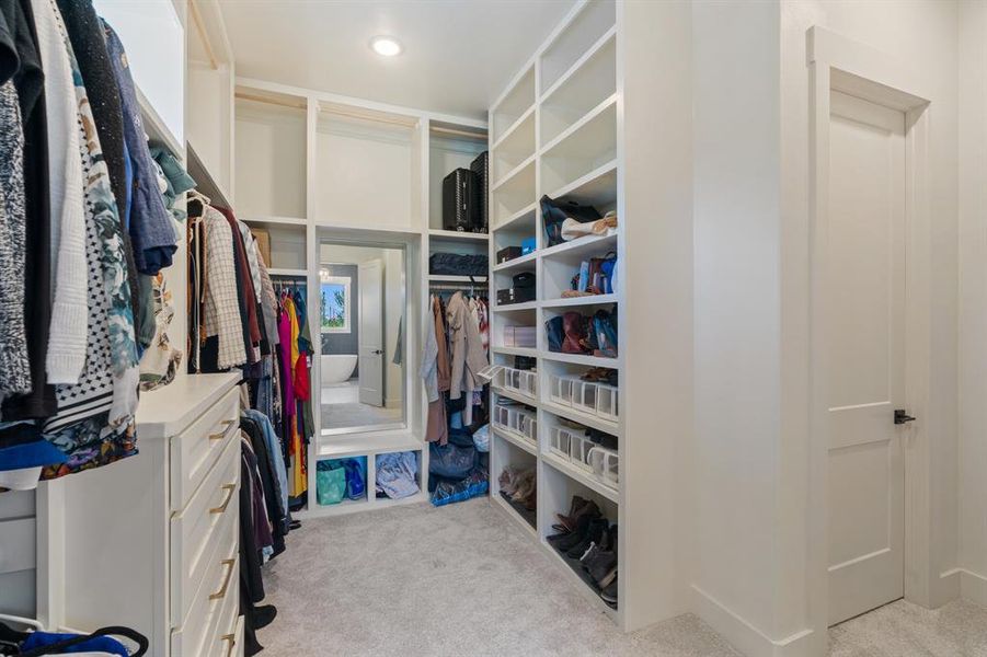 Spacious closet featuring custom closet system