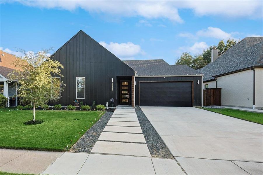 View of front facade with a garage and a front lawn