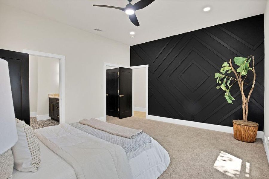 Carpeted bedroom with ceiling fan and connected bathroom