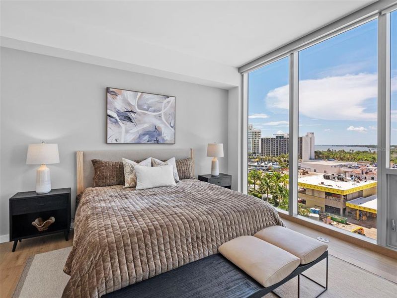 Primary bedroom with floor to ceiling windows