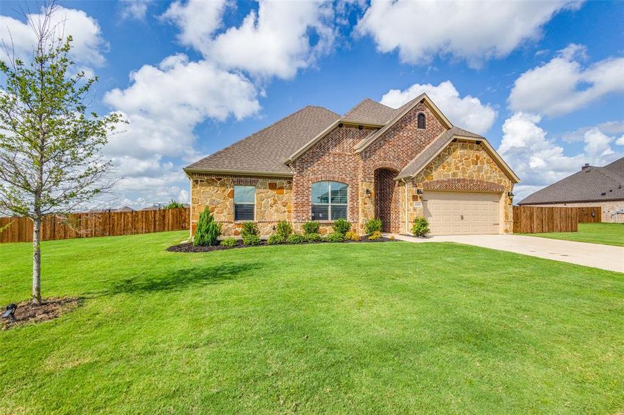 View of front of house featuring a garage and a front lawn