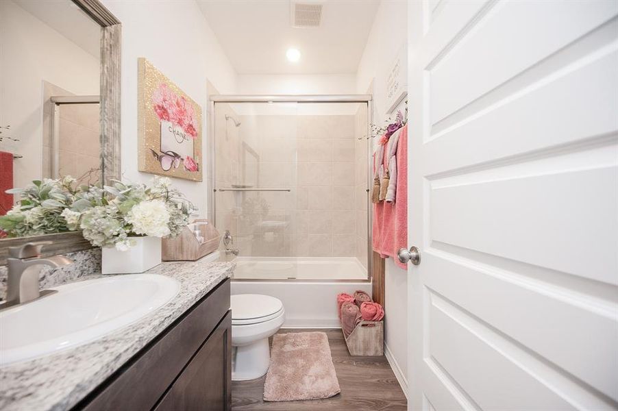 This is the private bathroom for bedroom 3.  Again, the seller swapped out the builder grade plumbing faucet w/ a sleek & modern fixture, framed out the mirror, and added the seamless glass enclosure to the tub.