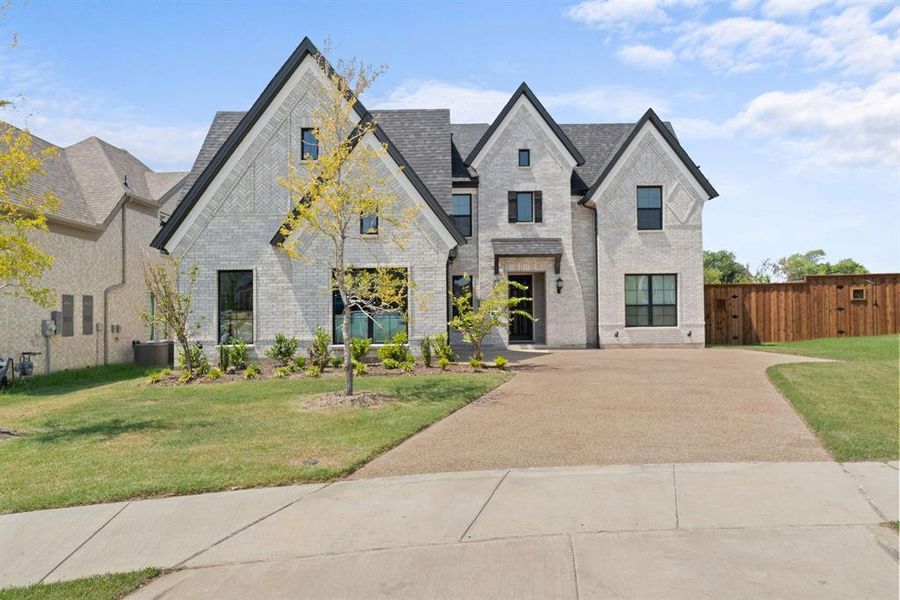 French provincial home featuring a front lawn