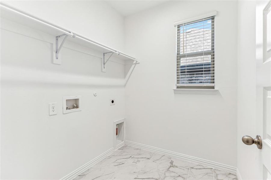 Laundry area with hookup for a washing machine, gas dryer hookup, and electric dryer hookup