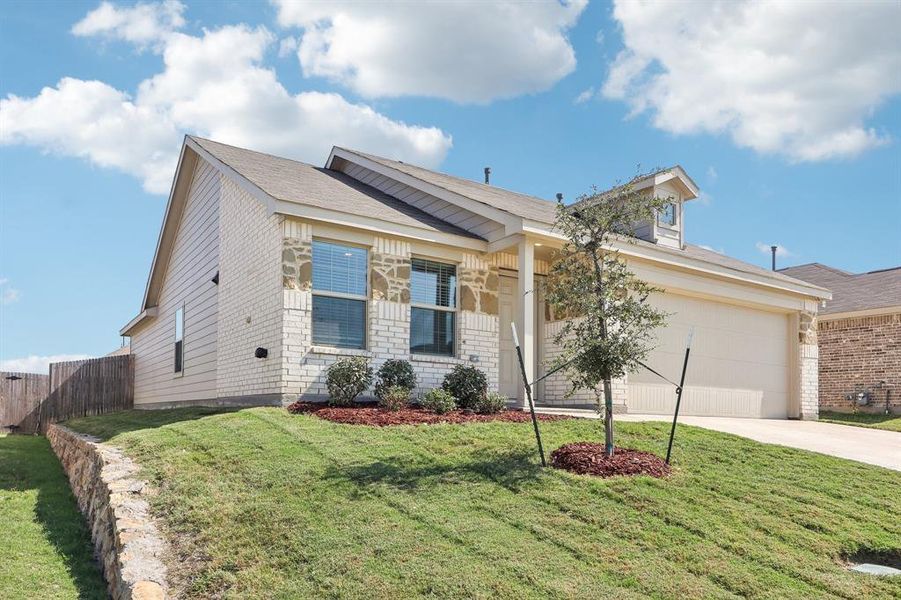 View of front of house featuring a front yard and a garage