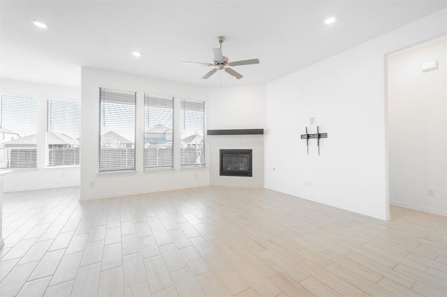 Unfurnished living room featuring light hardwood / wood-style floors, a fireplace, and ceiling fan