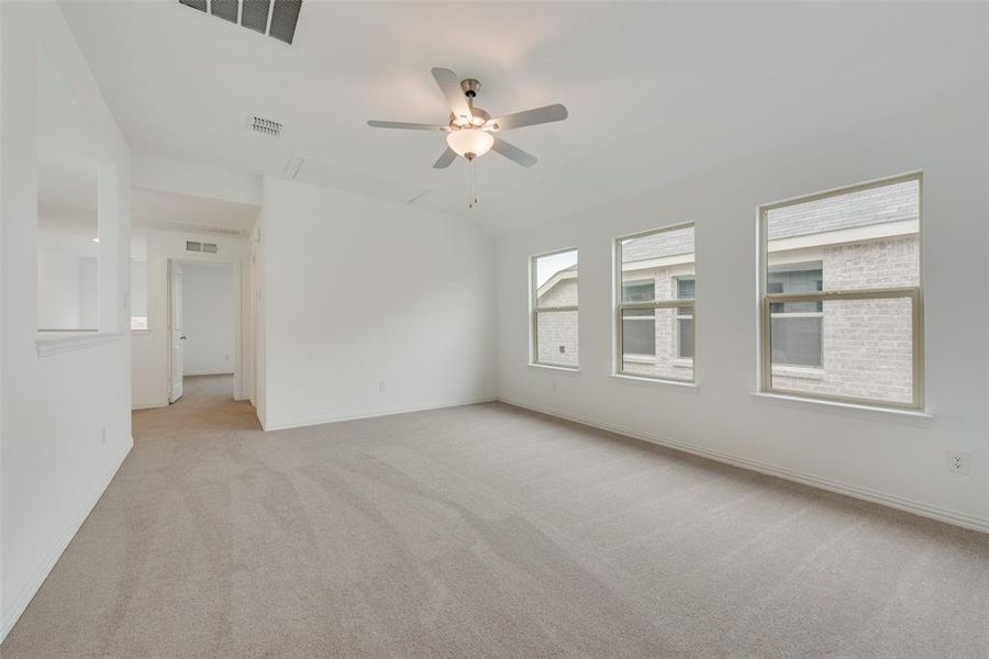 Empty room with ceiling fan and light colored carpet