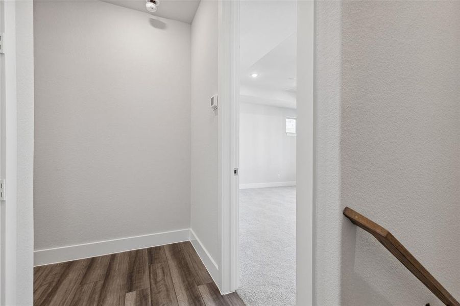 Corridor featuring dark colored carpet