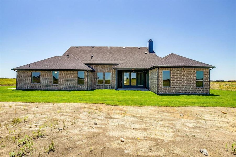 Back of house with a lawn