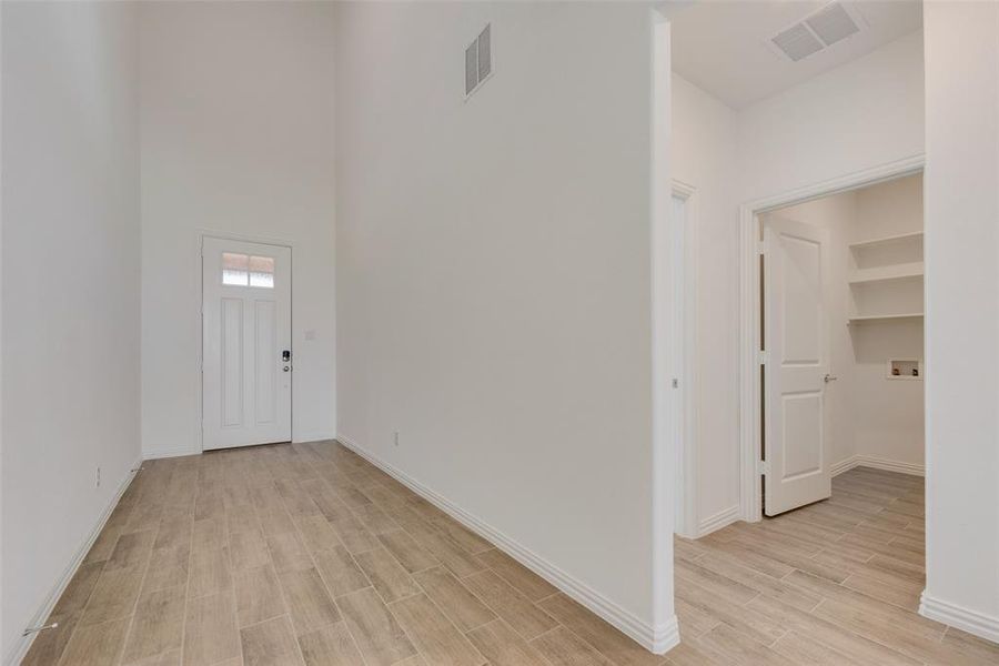 Entryway with light wood-type flooring and a high ceiling