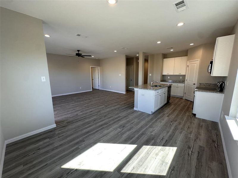 Kitchen featuring a kitchen island with sink, white cabinetry, ceiling fan, and dark hardwood / wood-style floors