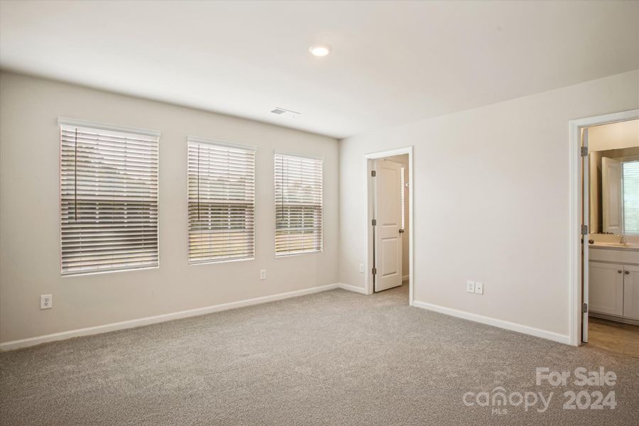 wall of windows in Primary bedroom offers abundance of natural light