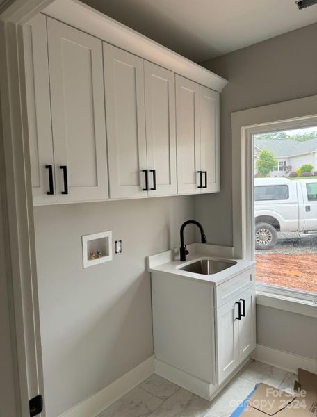 Laundry room with quartz counter top utility sink and soft close cabinets and doors