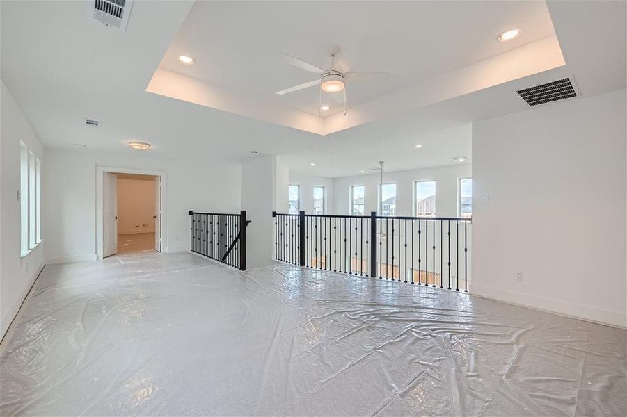 Game room with a tray ceiling and ceiling fan