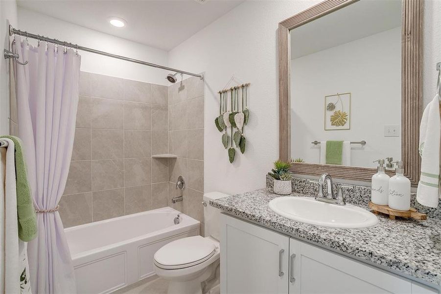 Full bathroom with shower / bath combination with curtain, vanity, and toilet