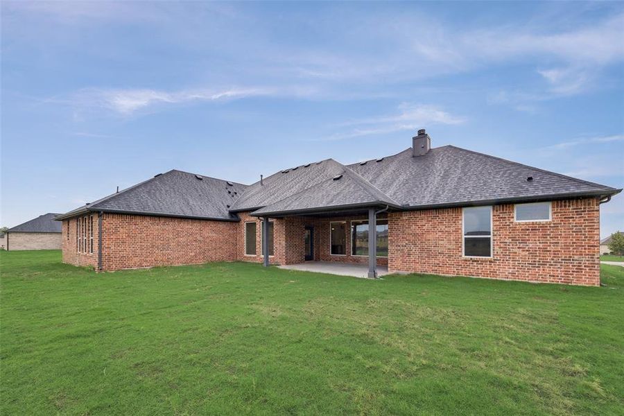 Rear view of property featuring a yard and a patio