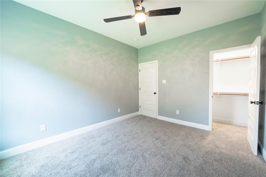 Unfurnished bedroom featuring ceiling fan, light carpet, and a closet