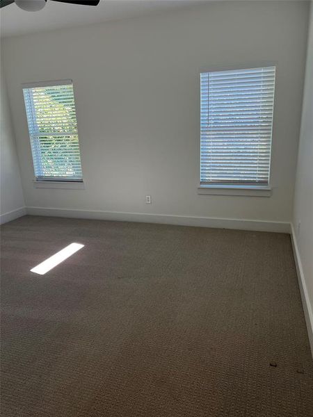 Carpeted empty room with ceiling fan