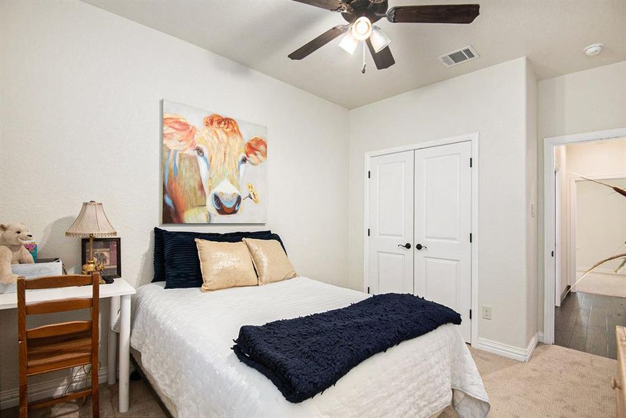 Bedroom with light hardwood / wood-style floors, a closet, and ceiling fan