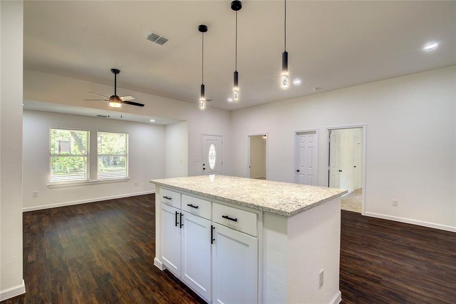 Kitchen featuring decorative light fixtures, white cabinetry, ceiling fan, and dark hardwood / wood-style floors