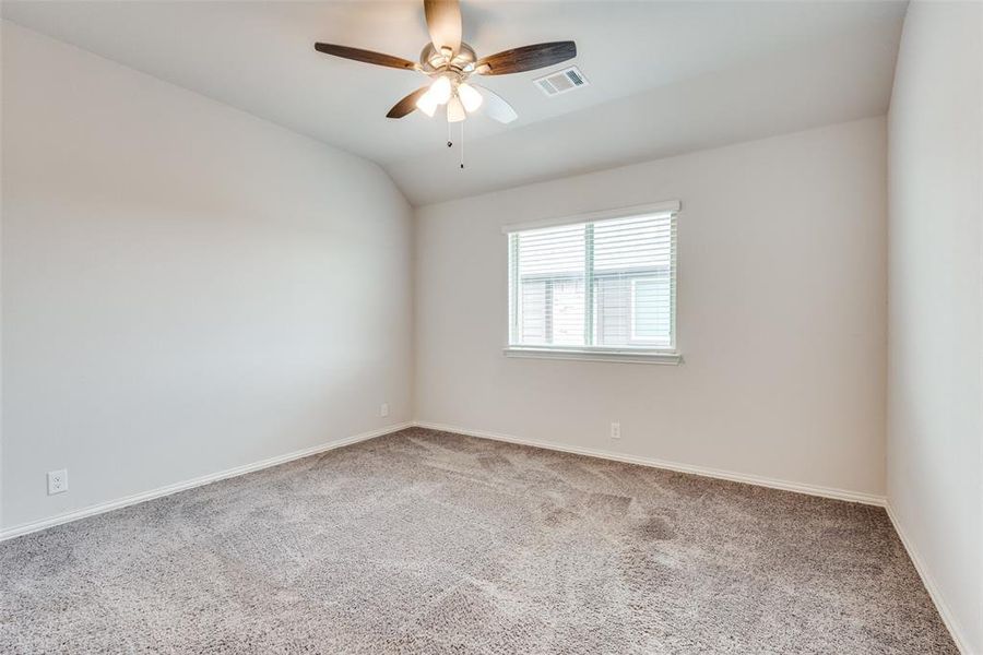 Carpeted spare room with vaulted ceiling and ceiling fan