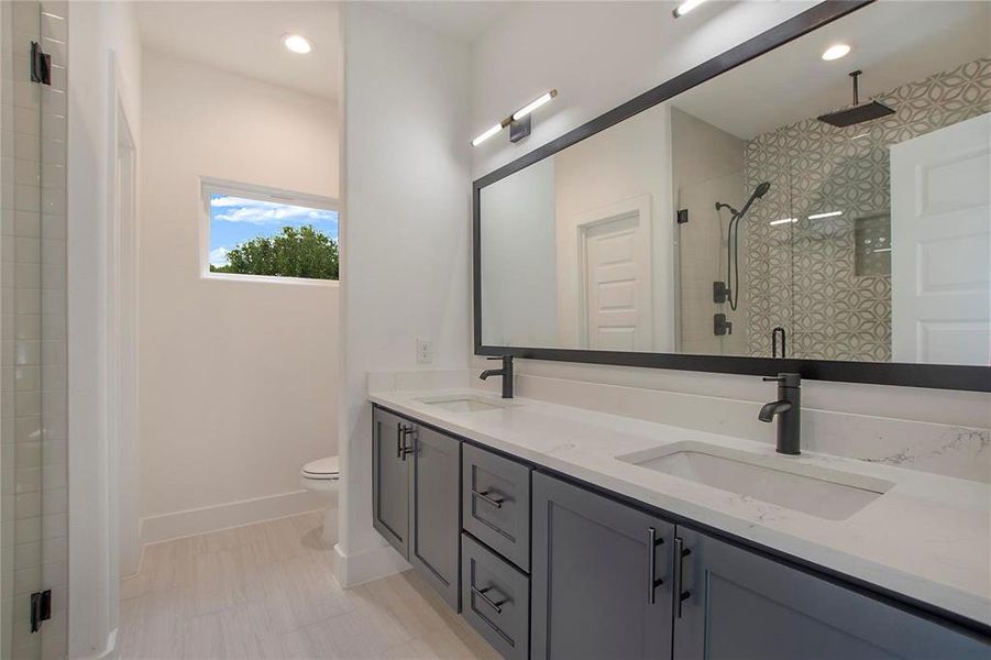 Bathroom featuring a shower with shower door, vanity, and toilet