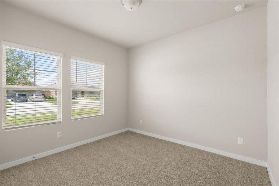 An additional view of the Secondary bedroom on main floor which offers plush carpet, neutral finishes and oversized closet.