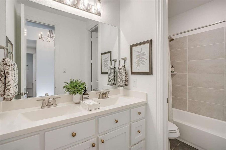 Full bathroom featuring tile patterned flooring, shower / bath combo with shower curtain, vanity, and toilet