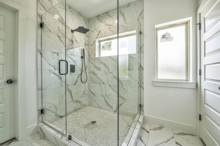 Bathroom featuring a wealth of natural light and a shower with door