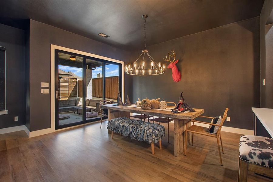 Dining area with wood-type flooring and a chandelier