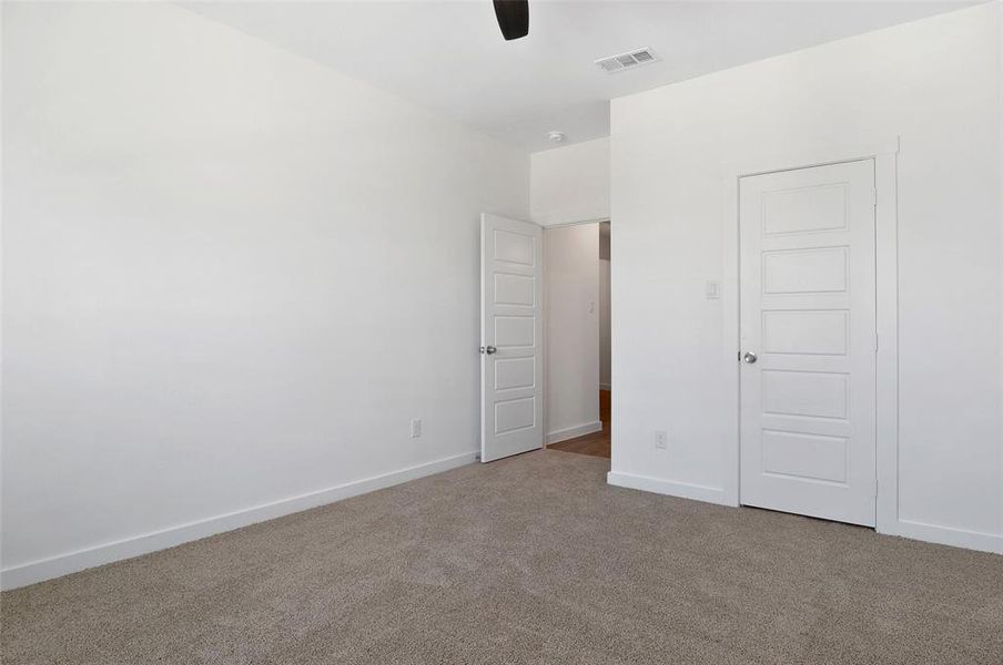 Unfurnished bedroom featuring a closet, ceiling fan, and light colored carpet