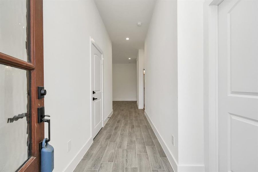 Step inside to find a spacious foyer. To the left, a door leads to the garage, while to the right, a door opens to the first bedroom.