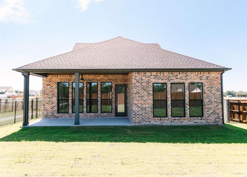 Rear view of property featuring a lawn and a patio area