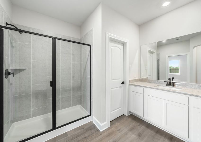 The master bathroom of the Reed has a large vanity space and glass, walk-in shower.