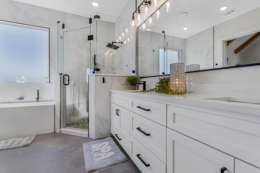 Bathroom featuring shower with separate bathtub, vanity, tile walls, and plenty of natural light