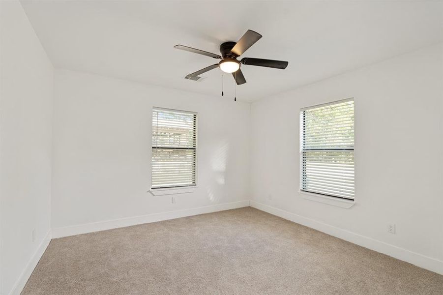 Unfurnished room featuring light carpet and ceiling fan