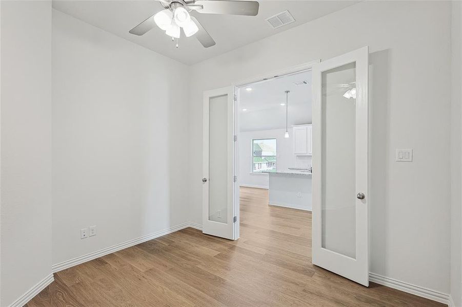 Empty room featuring ceiling fan and light hardwood / wood-style flooring