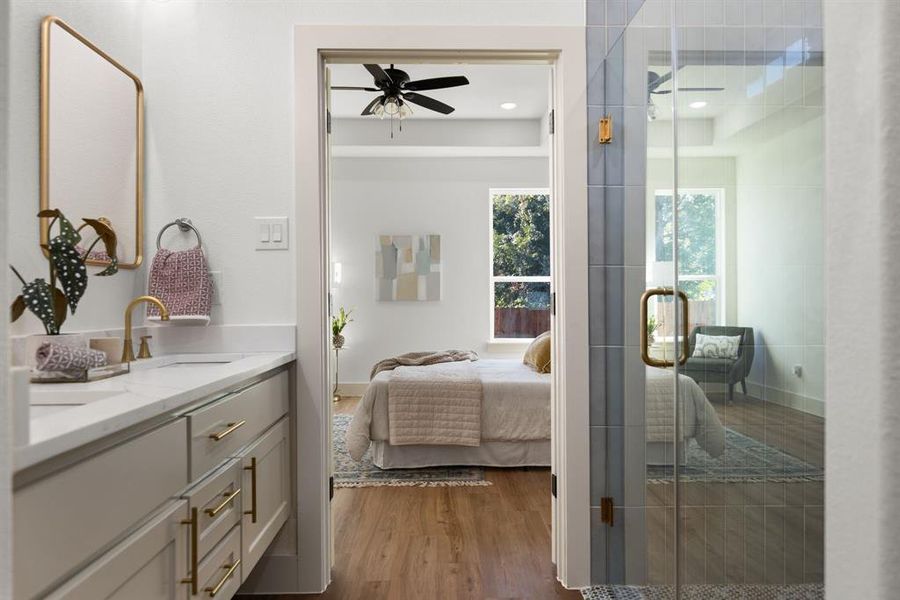 Bedroom with wood-type flooring, ceiling fan, and sink