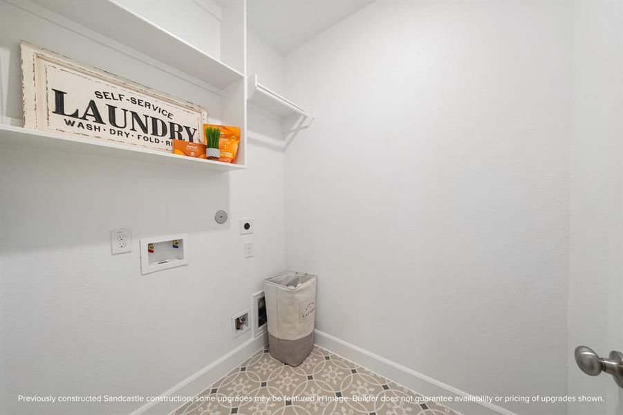 Make laundry day easier with a second-floor laundry room equipped for side-by-side washer and dryer, built-in shelving, and hanging space.