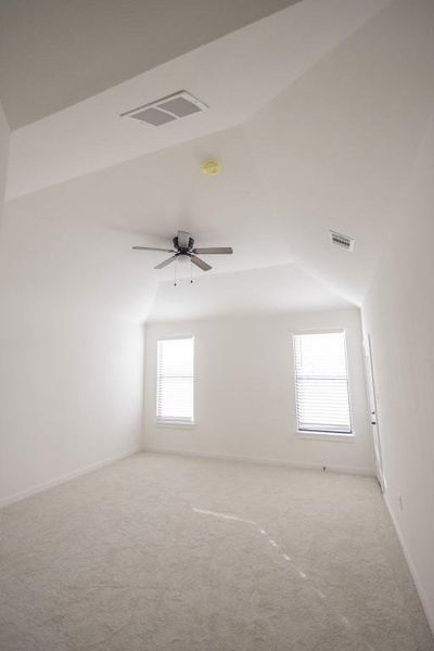 Empty room with carpet, ceiling fan, and vaulted ceiling