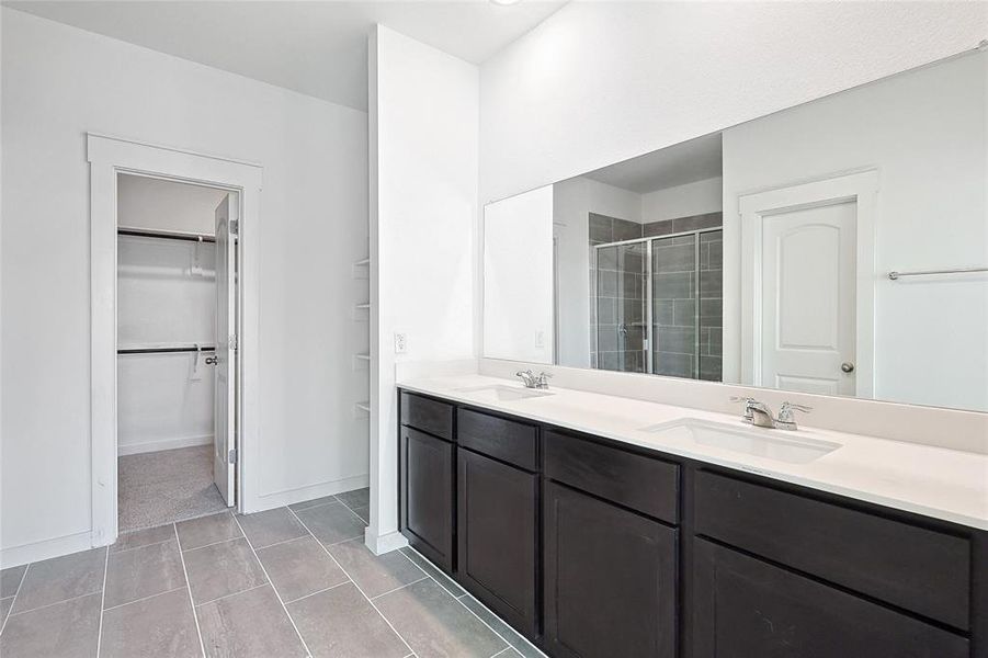 Bathroom with tile patterned flooring, walk in shower, and vanity