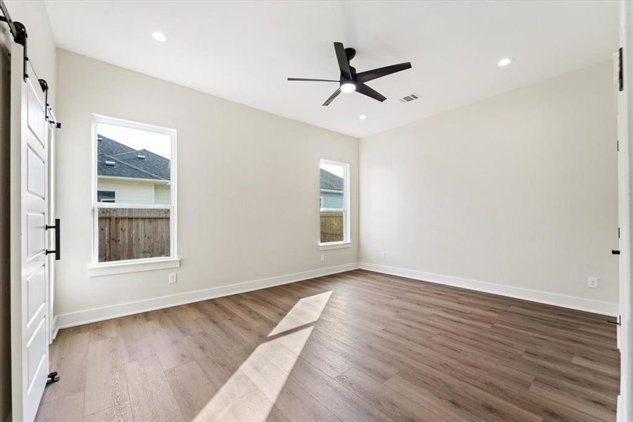 The primary bedroom! Spacious and modern, yet cozy and comforting. Complete with a ceiling fan, recessed lights, a walk in closet and a dream en-suite.