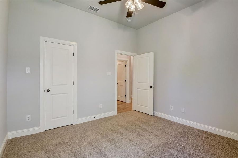 Carpeted empty room with ceiling fan