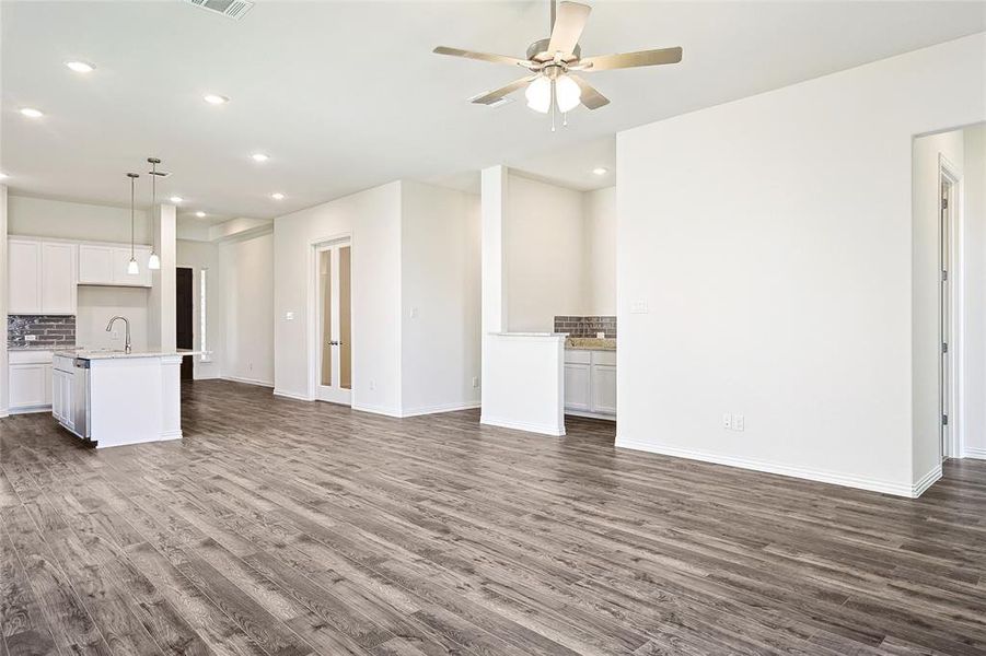 Unfurnished living room featuring ceiling fan, dark hardwood / wood-style flooring, and sink