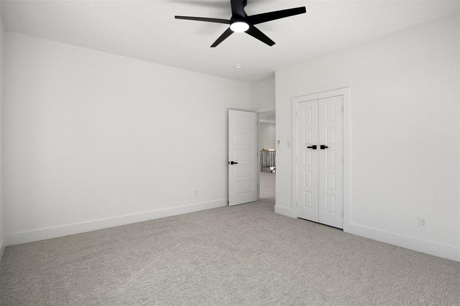 Unfurnished bedroom with a closet, ceiling fan, and light colored carpet