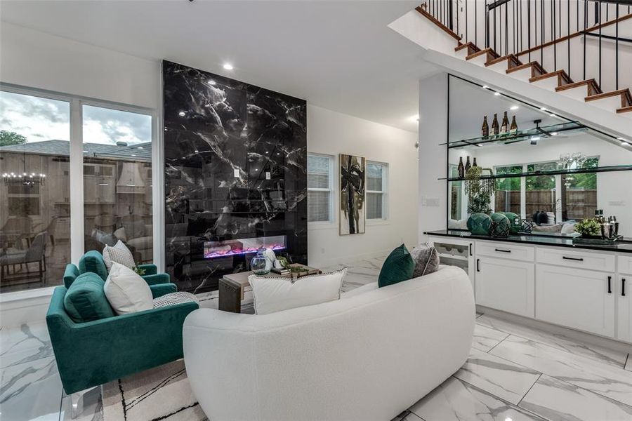 Living room featuring electric fireplace and bar.