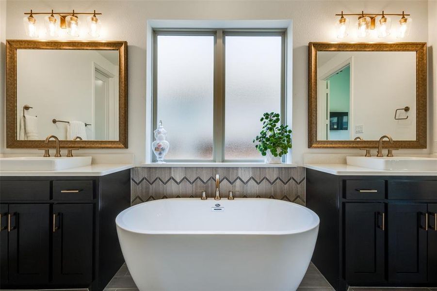 Bathroom featuring dual vanity, a healthy amount of sunlight, and tile patterned flooring