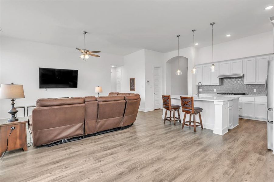 Living room with light hardwood / wood-style flooring, sink, and ceiling fan